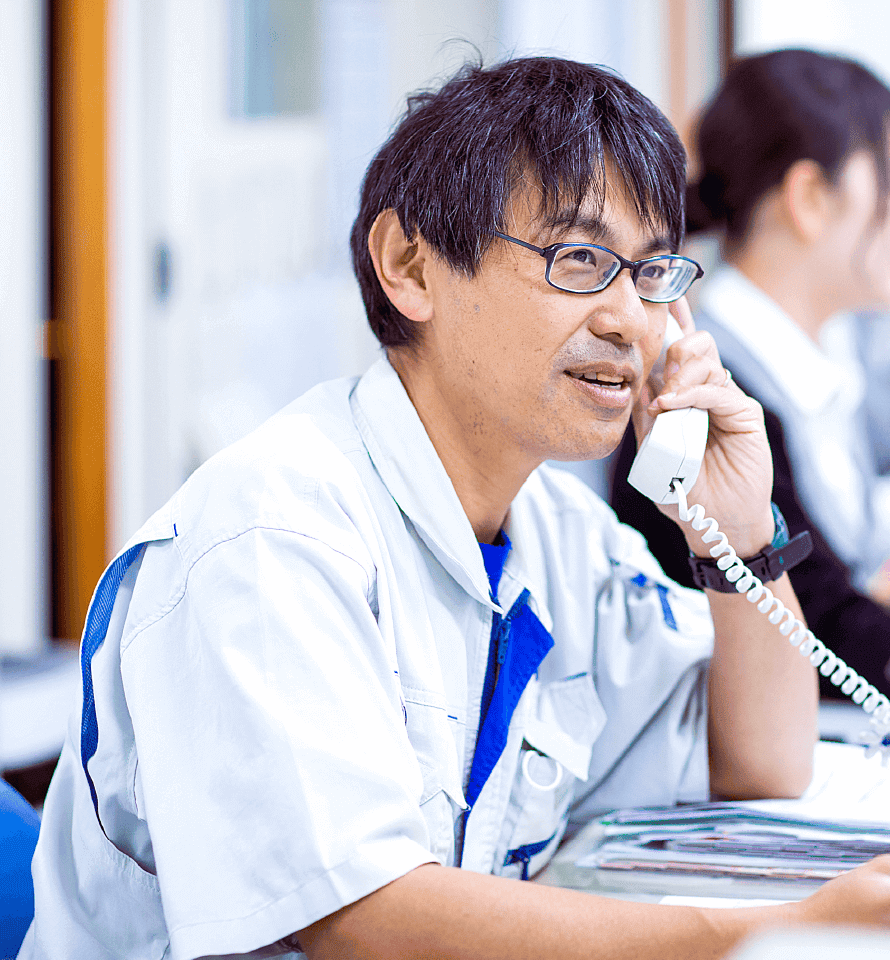 仕事中のスタッフイメージ1 電話対応中の男性従業員の仕事風景